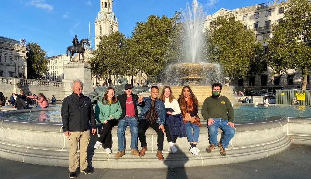 A group of people in front of a fountain.
