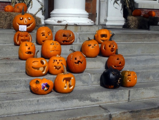 several carved pumpkins arranged on stairs