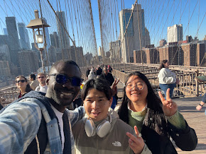 Group of international students posing in front of the Brooklyn Bride.