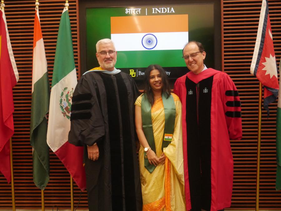 Indian student poses with sash. 